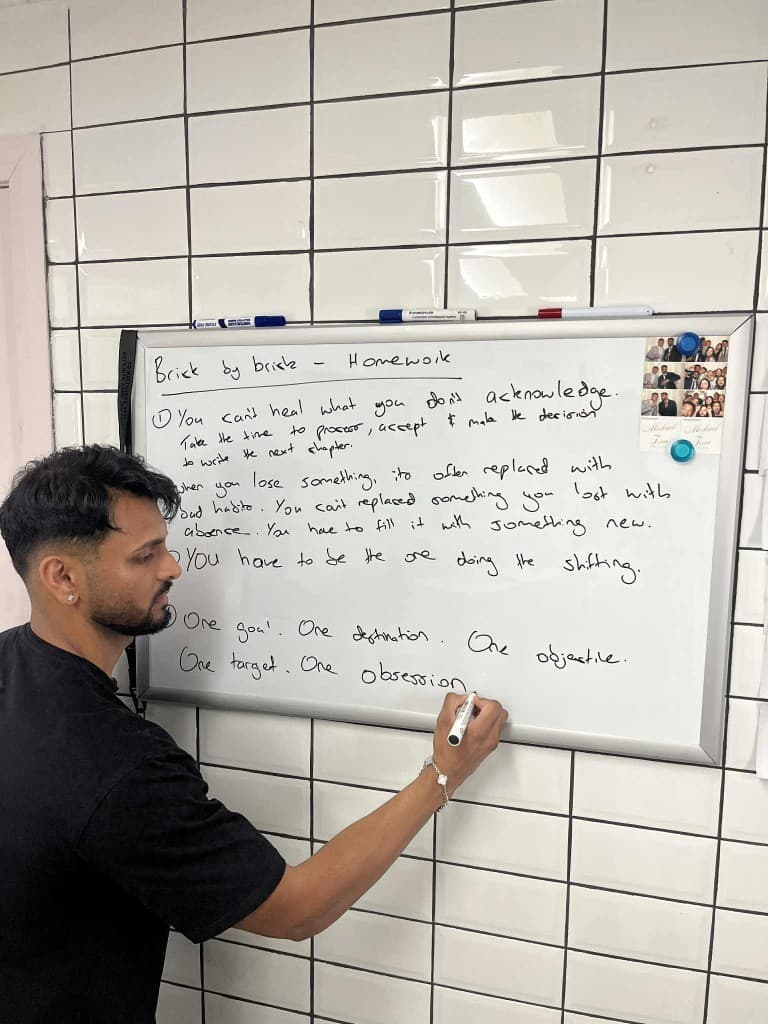 Shraz writing Brick By Brick homework on a whiteboard
